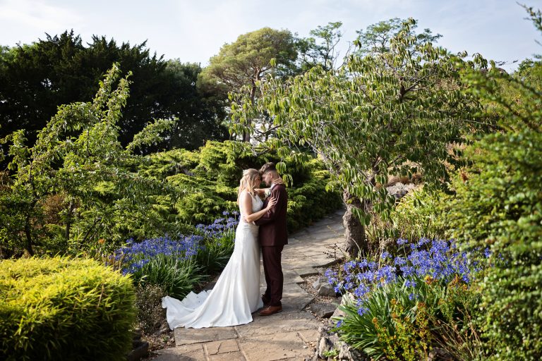 Bride and groom enjoy a quiet moment together amongst stunning summer gardens