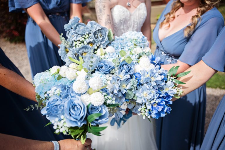 arms of bridesmaids holding their flowers in one big bunch