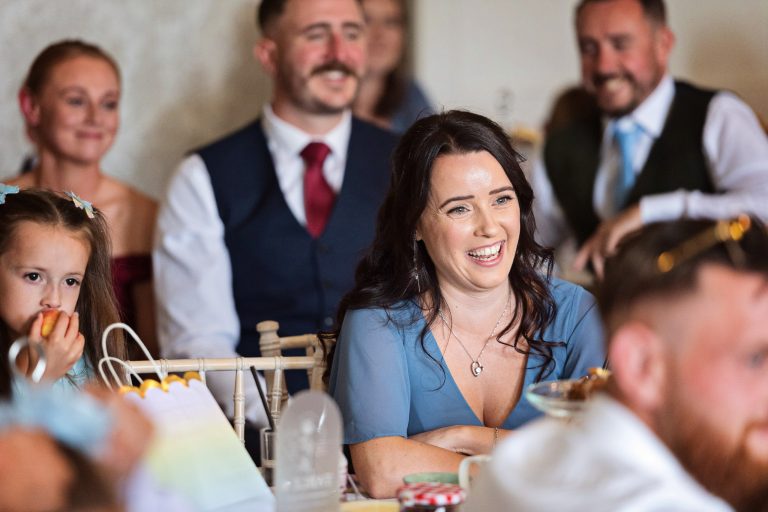 A Georgian dining room full of wedding guests listening to the speeches.