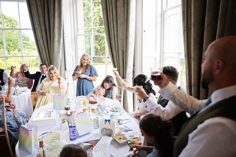 A Georgian dining room full of wedding guests listening to the speeches.