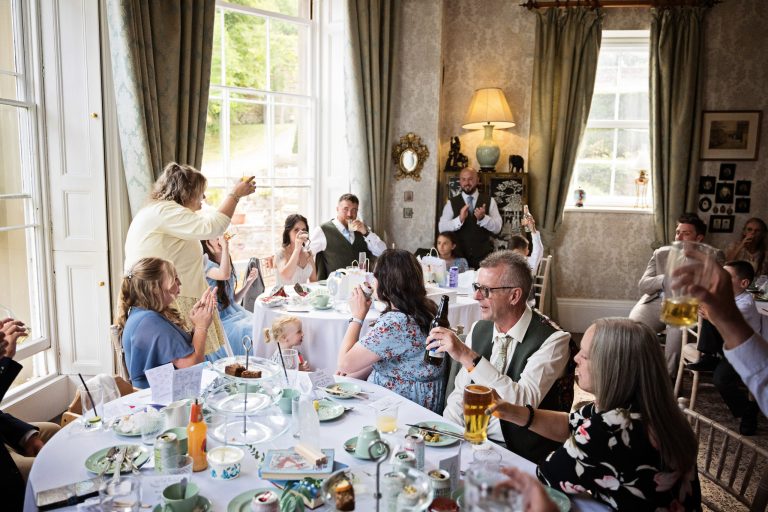 A Georgian dining room full of wedding guests listening to the speeches.