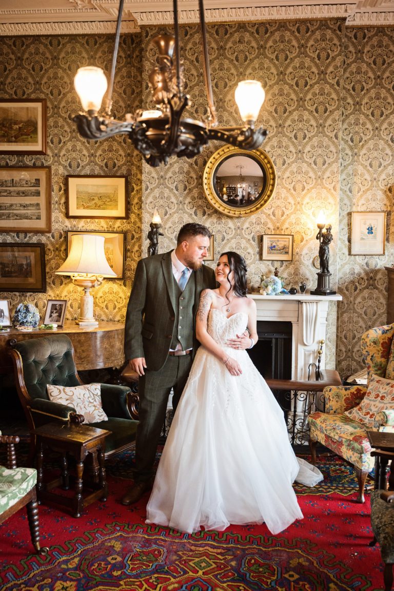 Georgian styled living room (old furniture and picture frames) with a bride and groom centre place in front of a beautiful fireplace.